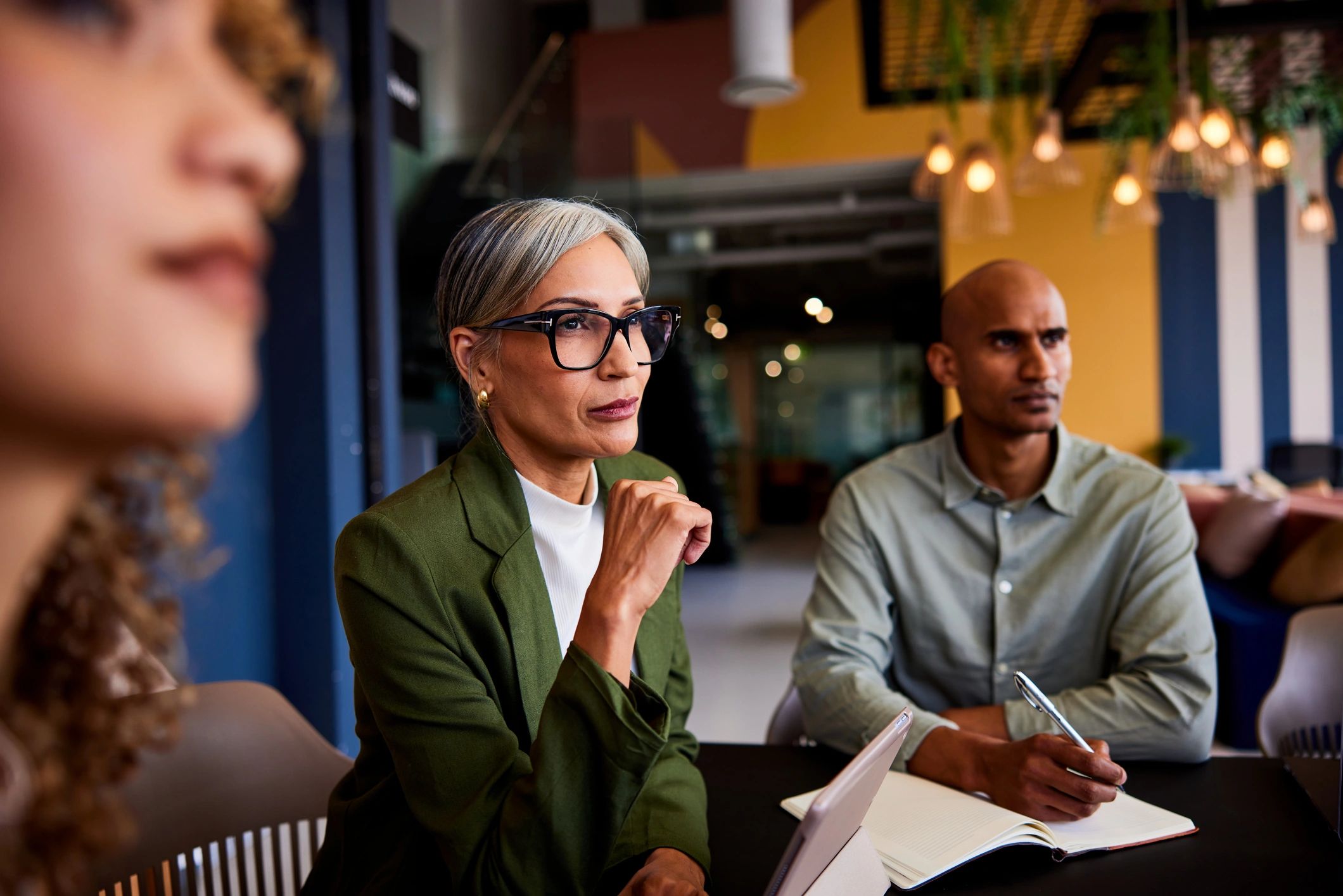 People attentively listening in a meeting.