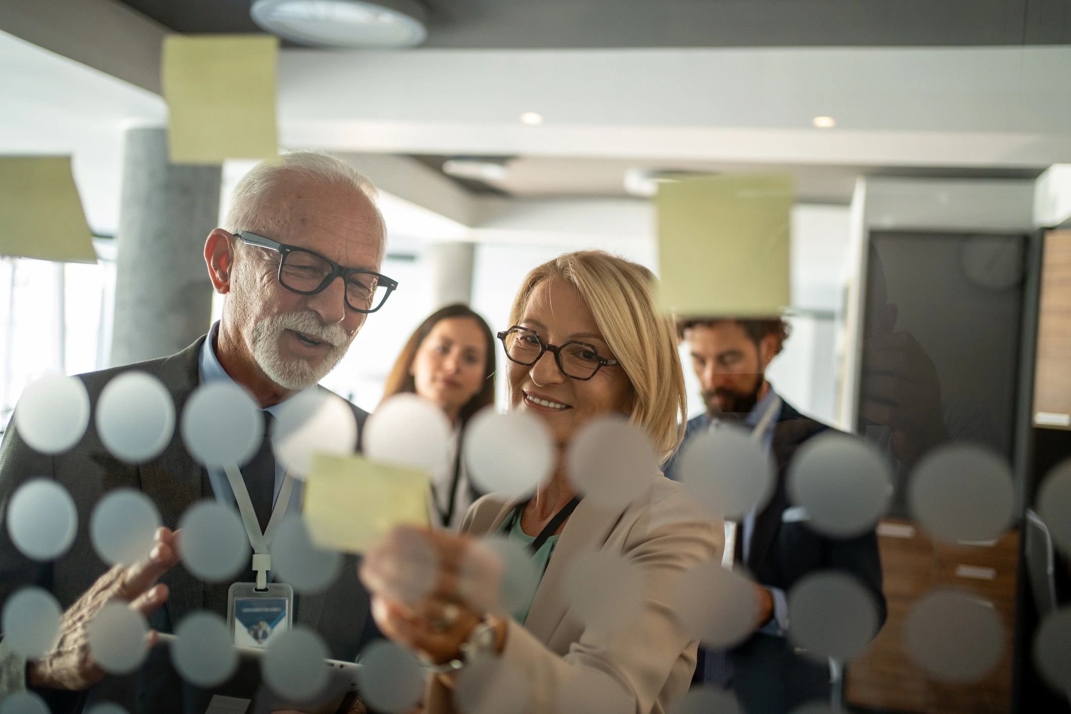 Business meeting with sticky notes on glass.