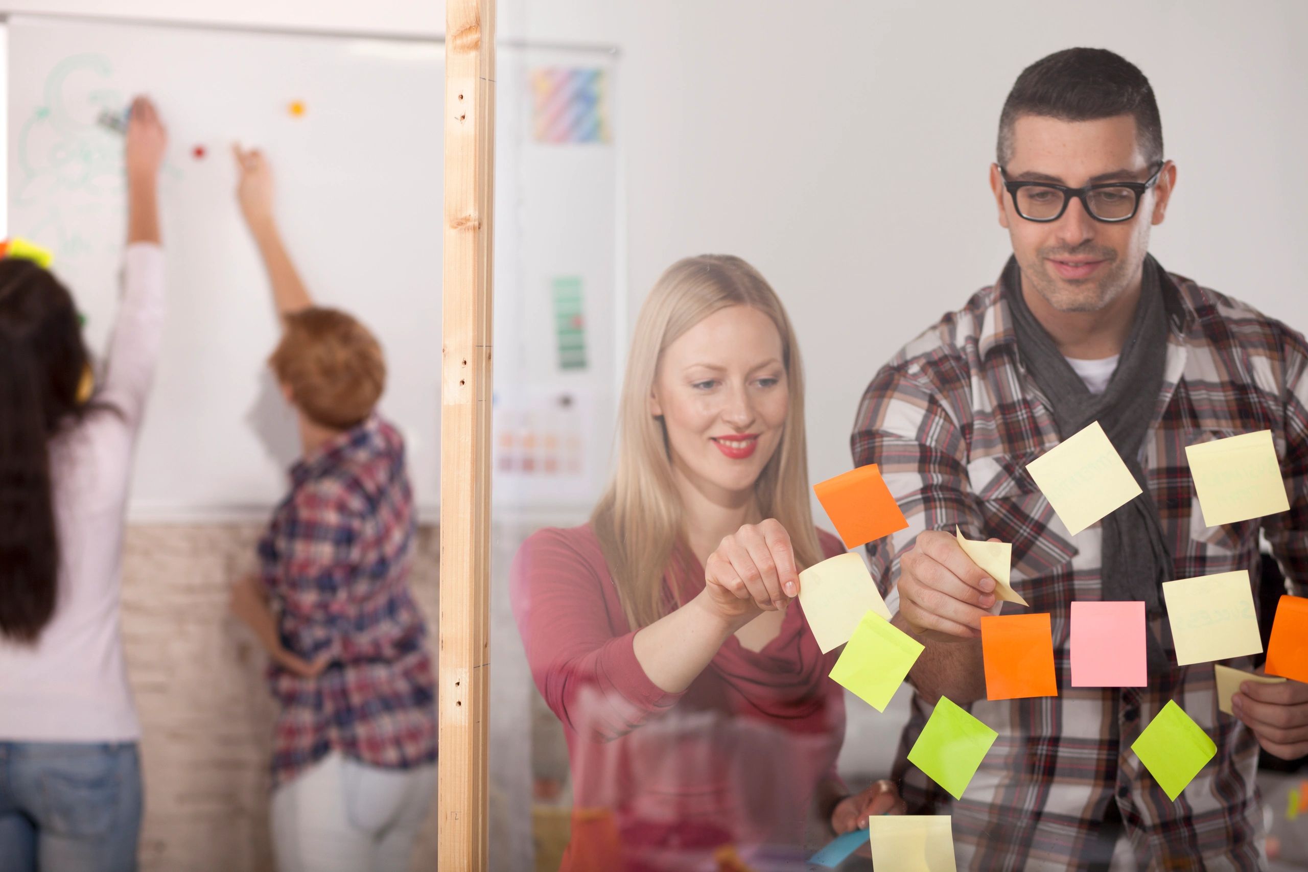 Team brainstorming with sticky notes and whiteboard.
